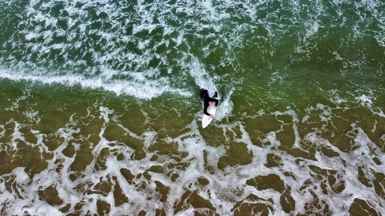 Surfeur sur une vague vu d'en haut par drone