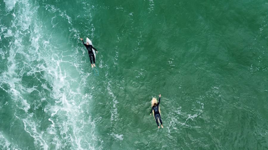Deux surfeurs à la rame vus d'en haut par drone