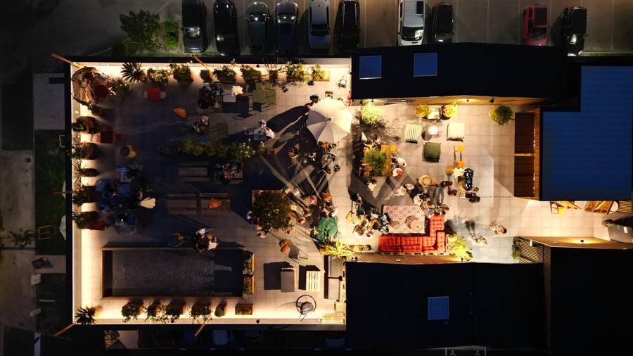Soirée sur un rooftop éclairé, vue verticale par drone